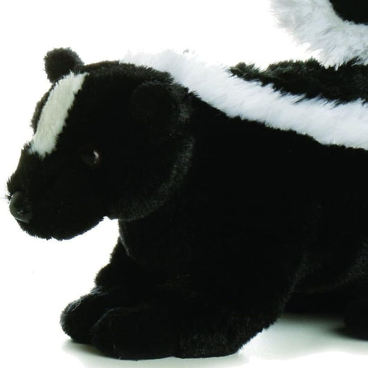 Close-up front profile of the skunk stuffed animal highlighting the white stripe on its face, dark eyes, and resting front paws.