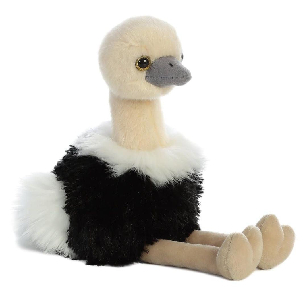 Angled side view of the Aurora Mini Flopsie Ozzi Ostrich 8-inch plush in a sitting position, featuring a black body, white feather trim, and long tan legs.