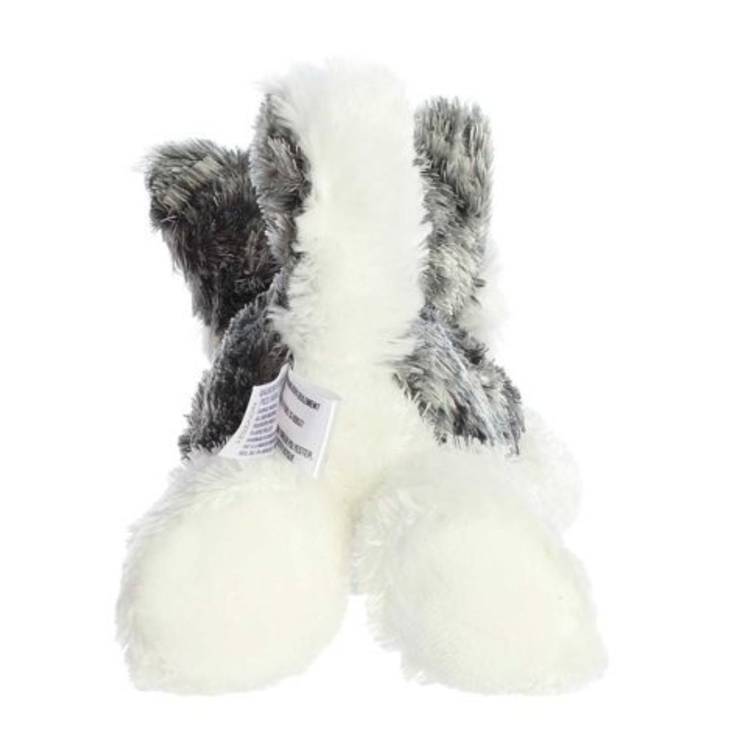 Rear view of the Husky plush showing its textured grey back, white hind legs, and an upright white-and-grey tail.