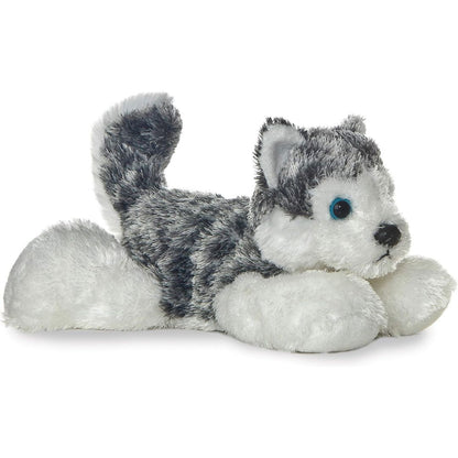 Angled side view of the Aurora Mini Flopsie Mush Husky 8-inch plush resting on its belly, featuring grey and white fur and a curled tail.