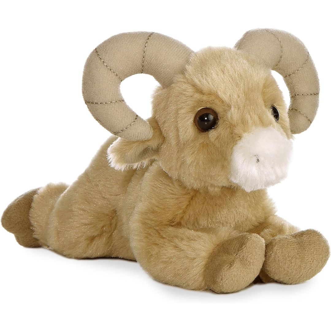 Angled side view of the Aurora Mini Flopsie Bighorn Sheep 8-inch plush resting on its belly, featuring sandy-tan fur and large curved horns.