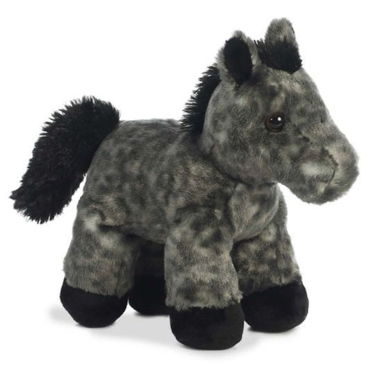 Angled view of the Aurora Mini Flopsie 8-inch Storm the Horse plush standing, showing its dappled grey and black fur and fluffy black mane.