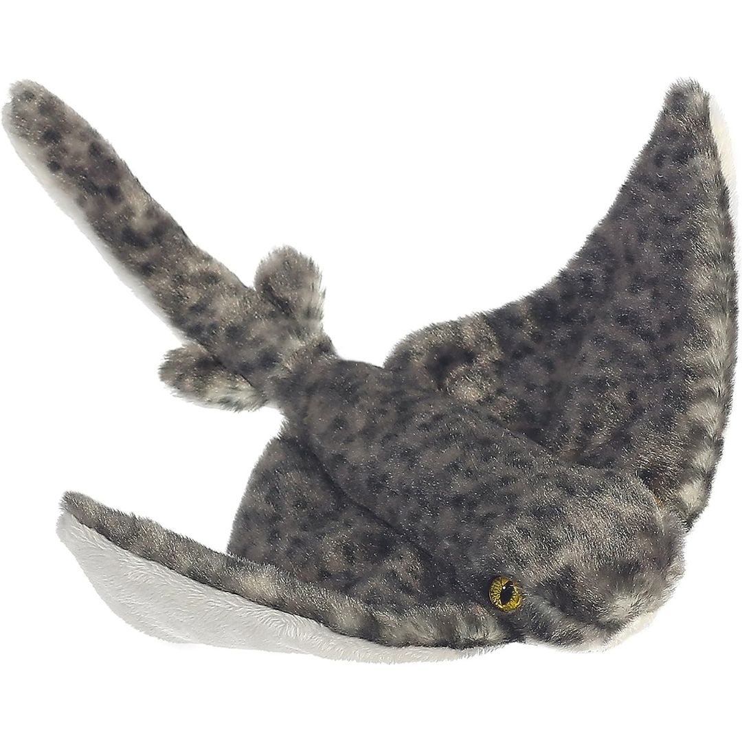 Angled top view of the Aurora Mini Flopsie Stingray 8-inch plush resting flat, featuring mottled grey camouflage fur and wide sweeping fins.