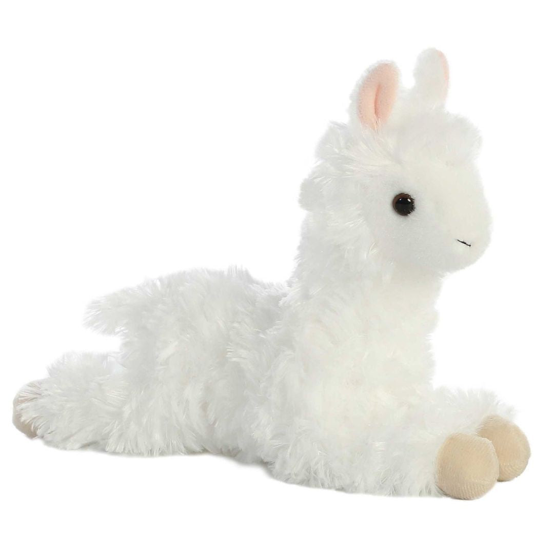 Angled side view of the Aurora Mini Flopsie Ansy Alpaca 8-inch plush resting on its belly, featuring fluffy wooly white fur.