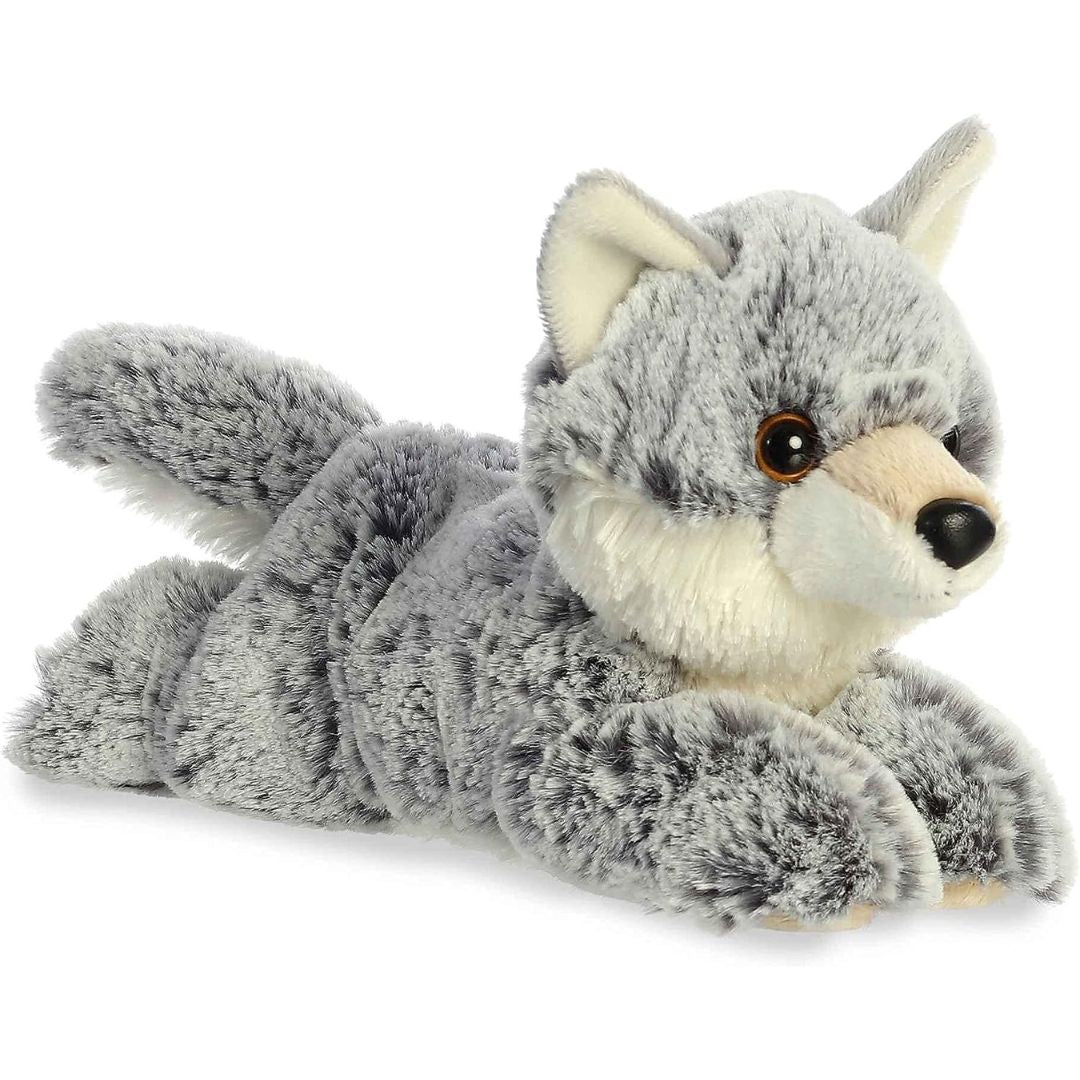 Angled view of the Aurora Mini Flopsie 8-inch Winter Wolf plush resting on its belly, showing its mottled grey fur and cream muzzle.