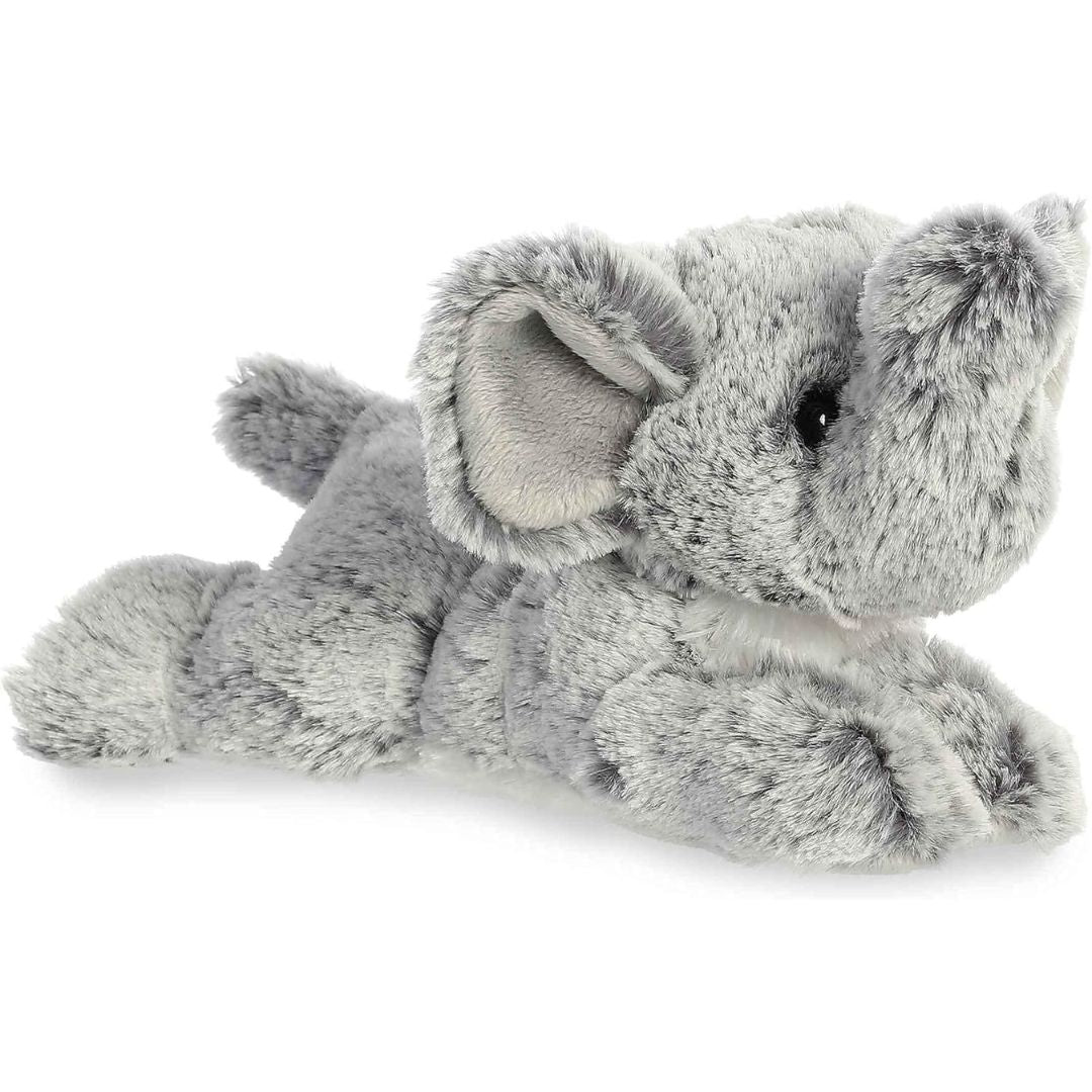 Angled side view of the Aurora Mini Flopsie Leroy Elephant 8-inch plush resting on its belly, featuring soft grey fur and an upturned trunk.