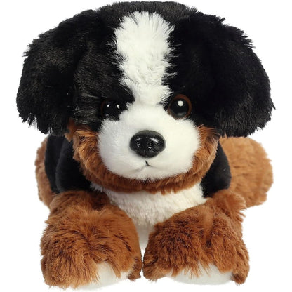 Direct front view of the soft black, brown, and white plush mountain dog lying down.