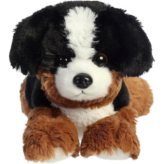 Direct front view of the soft black, brown, and white plush mountain dog lying down.