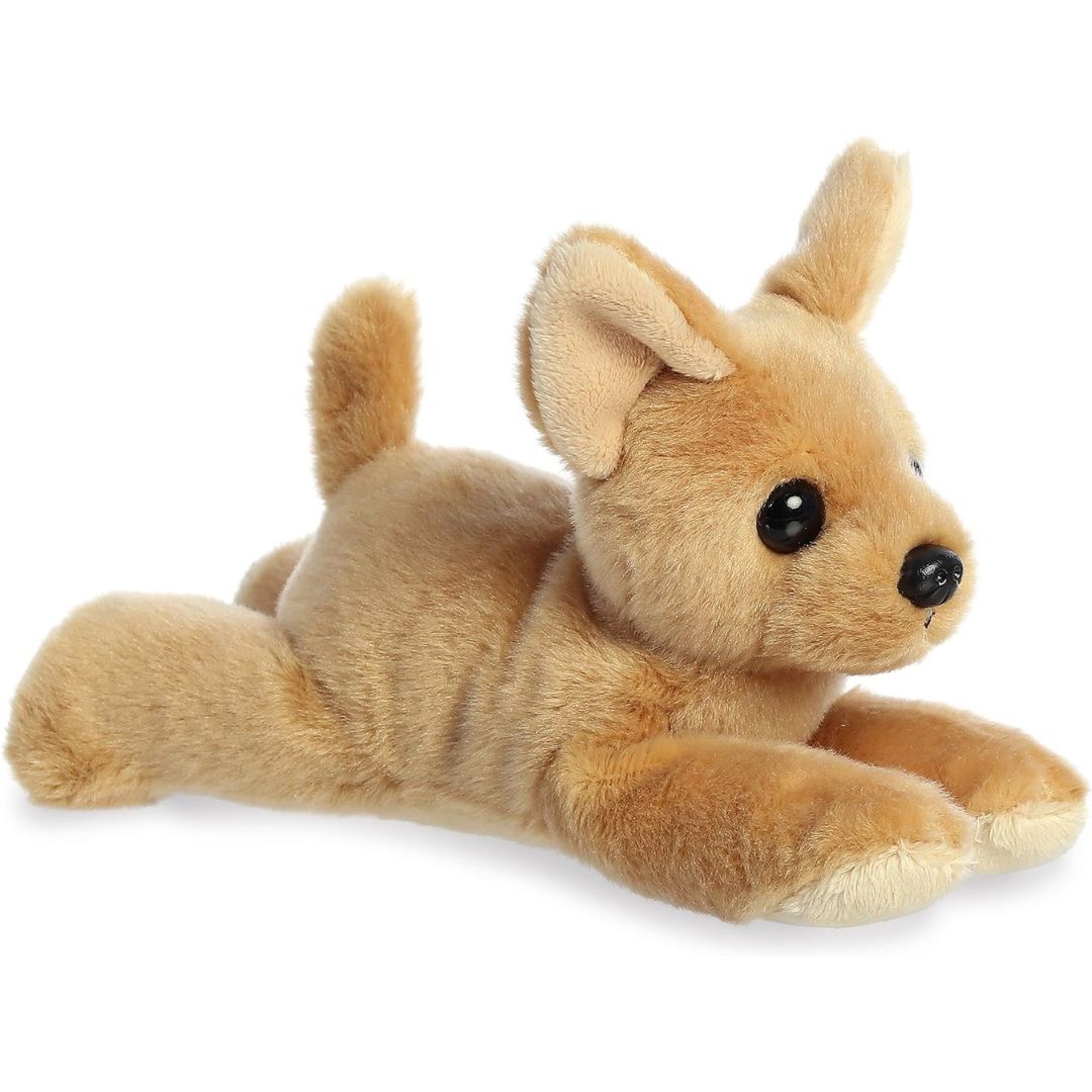 Angled side view of the Aurora Mini Flopsie Chia Chihuahua 8-inch plush resting on its belly, featuring soft tan fur and large perky ears.