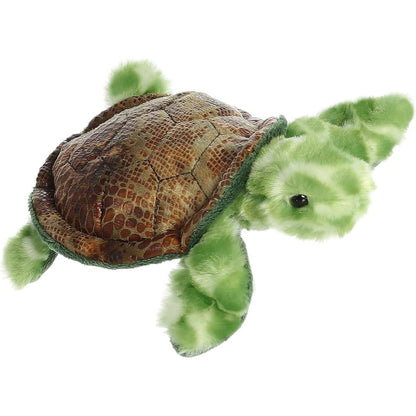 Angled view of the Aurora Mini Flopsie 8-inch Splish Sea Turtle plush resting on its belly, showing its brown shell and green flippers.