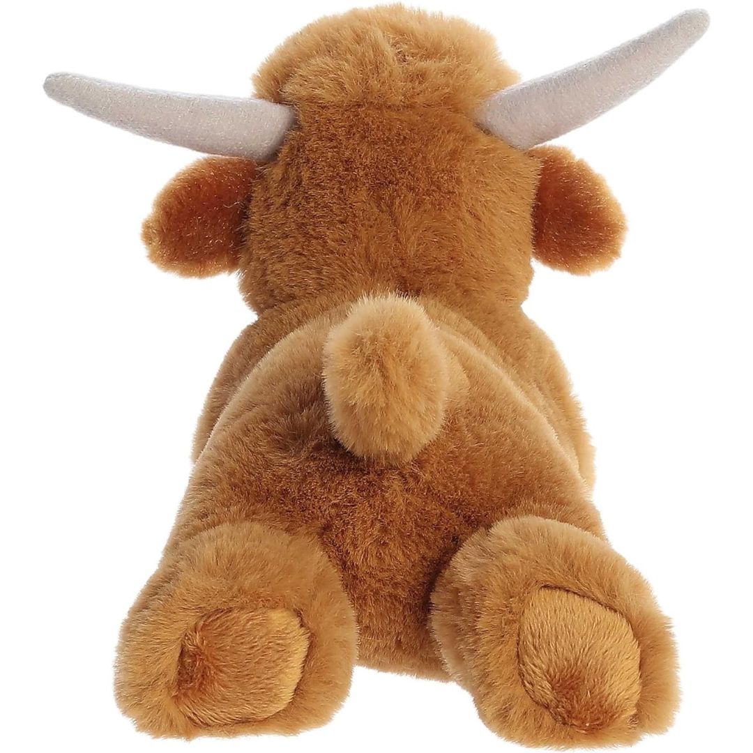 Direct back view of the cuddly cow stuffed animal highlighting its short perky tail and fluffy back legs.