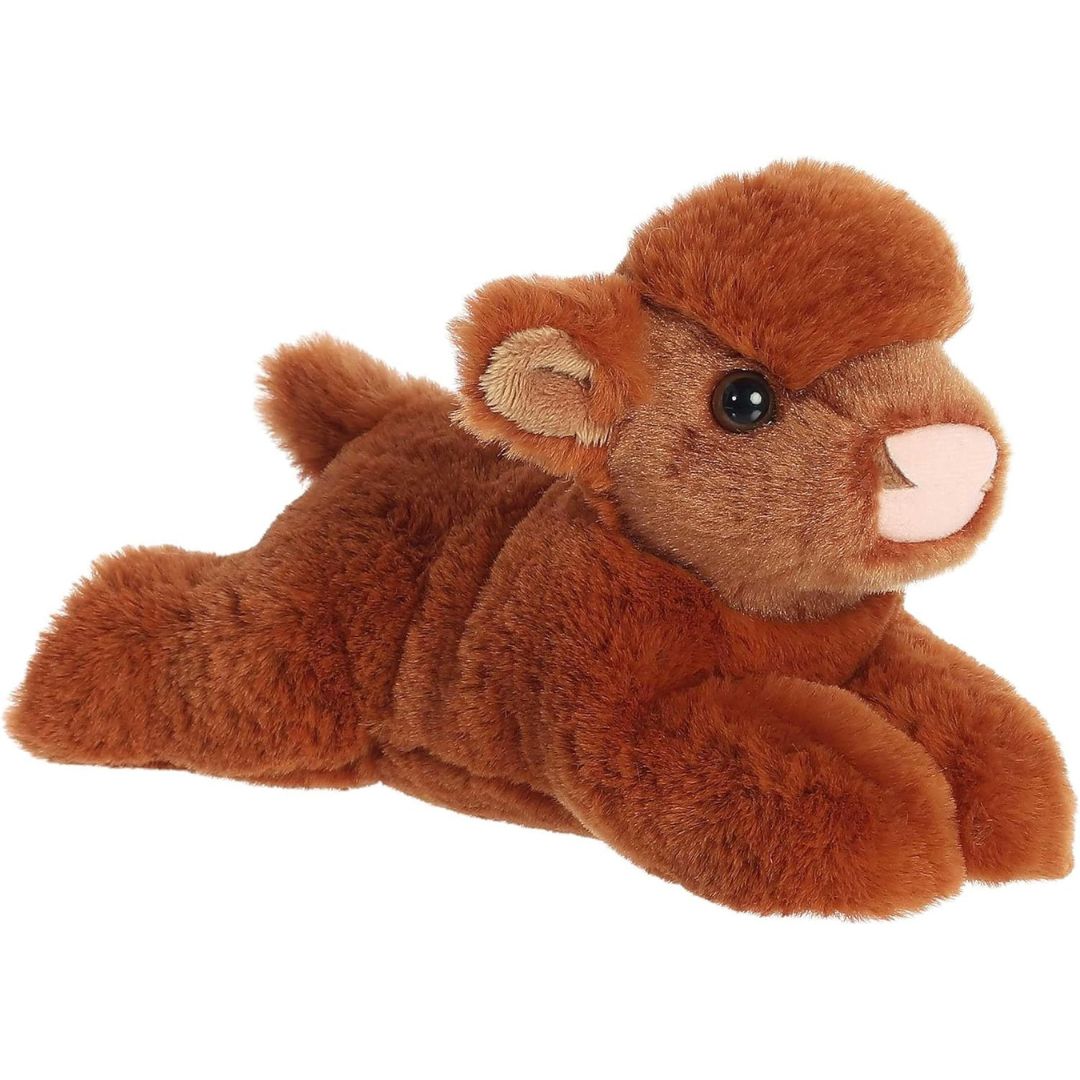 Angled side view of the Aurora Mini Flopsie Highland Cow Calf 8-inch plush resting on its belly, featuring shaggy ginger-brown fur.