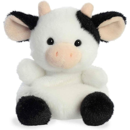 Straight-on front view of the soft black and white Palm Pals cow stuffed animal featuring a peach snout and horns.