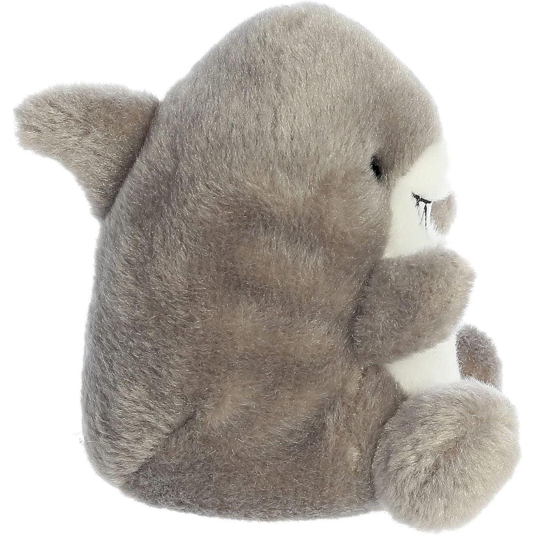 Side profile view of the Palm Pals Shark plush highlighting its perfectly squishy round body, white belly, and grey dorsal fin.