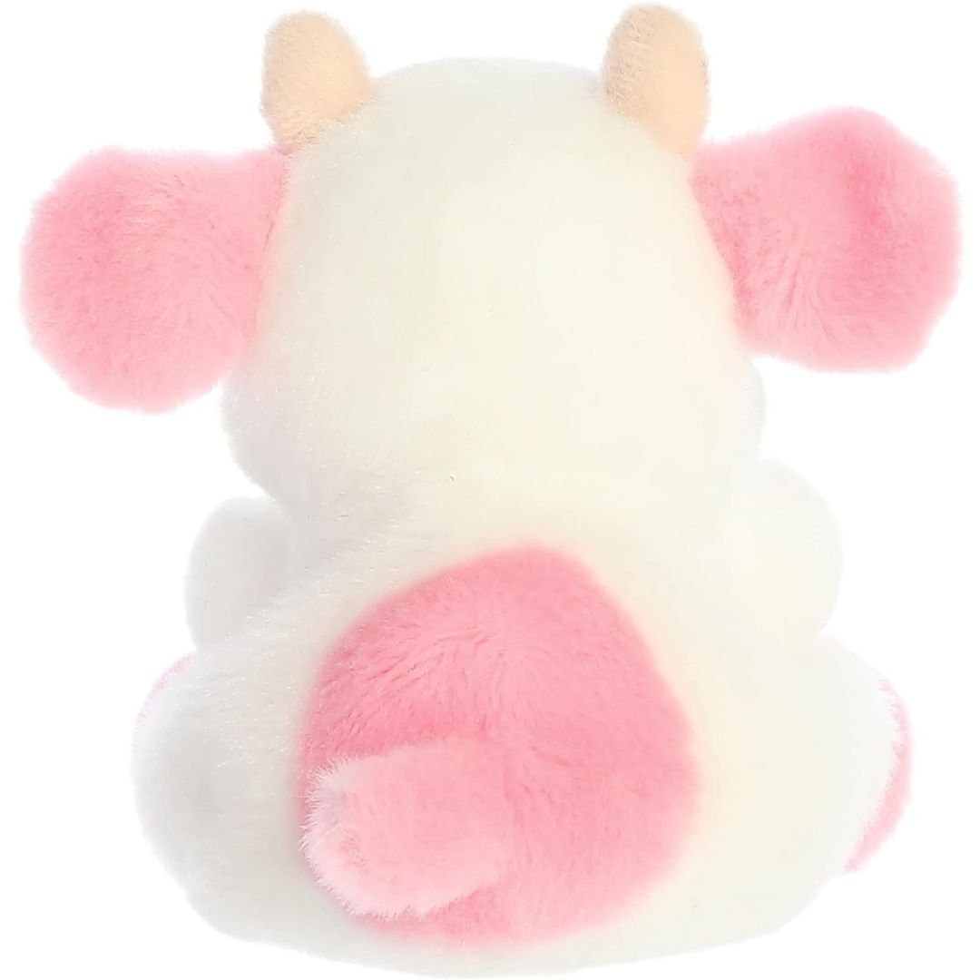 Back view of the Aurora Palm Pals cow plush toy showing a large pink spot on its white back and a cute pink tail.