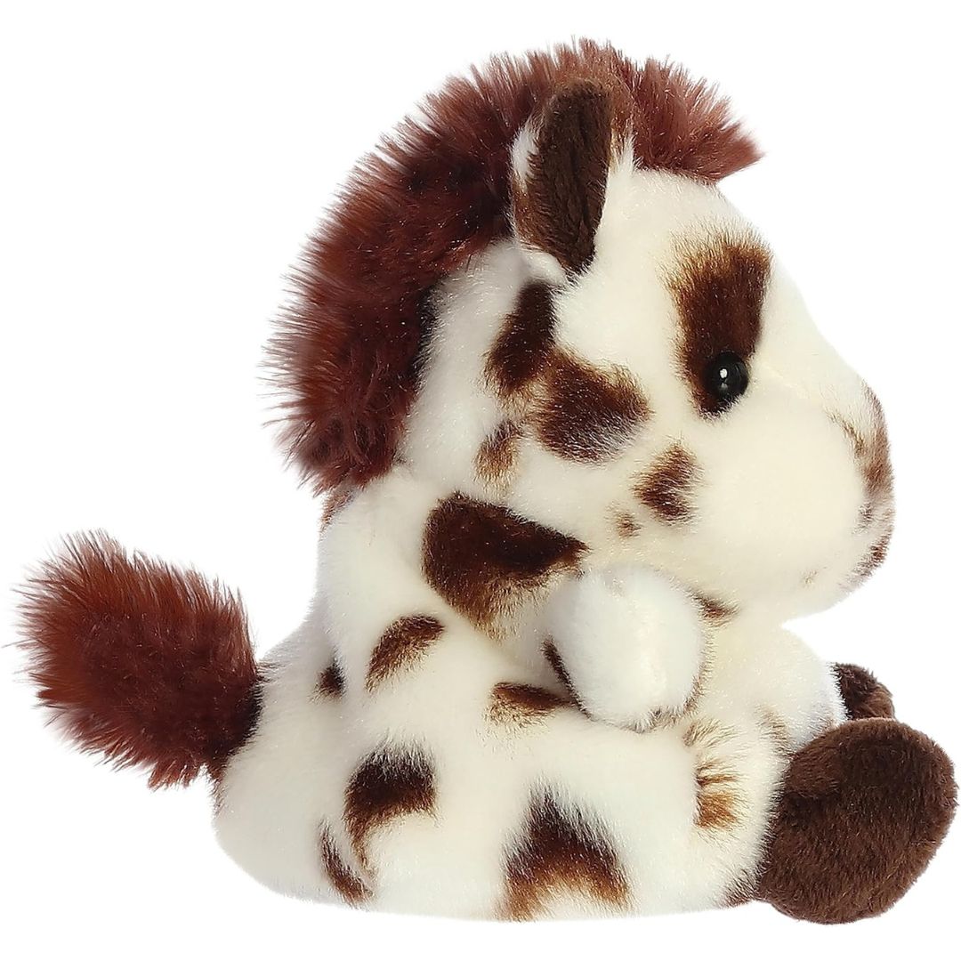 Side profile view of the Palm Pals Painted Horse plush toy highlighting its fluffy brown mane and bean-weighted sitting posture.