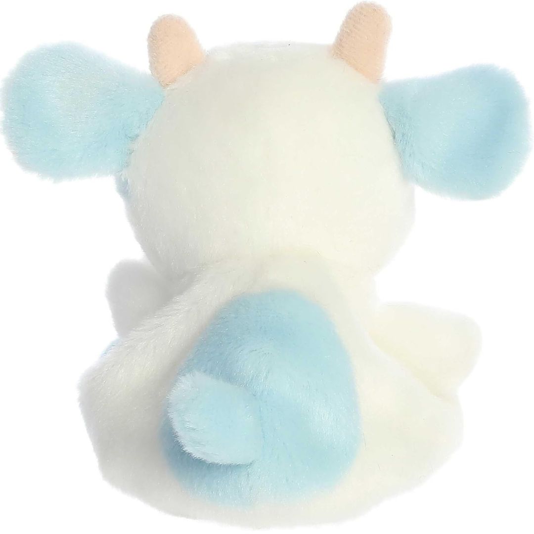 Rear view thumbnail of the Aurora cow stuffed toy displaying its smooth white plush backing, outspread blue ears, peach horns, and blue tail.