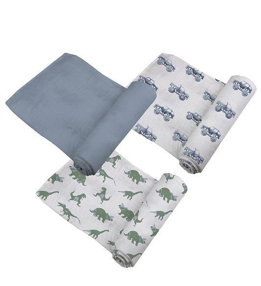 Three rolled 47x47 cotton muslin swaddles showing the green dinosaur, blue truck, and solid slate blue patterns.