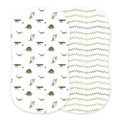 Newcastle Classics two-pack cotton bassinet sheets showcasing the Dino Days dinosaur scene print and green Dino Feet tracks print side-by-side.