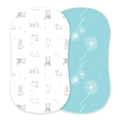 Newcastle Classics two-pack bamboo bassinet sheets showcasing the white Corgi puppy print and aqua blue dandelion print side-by-side.