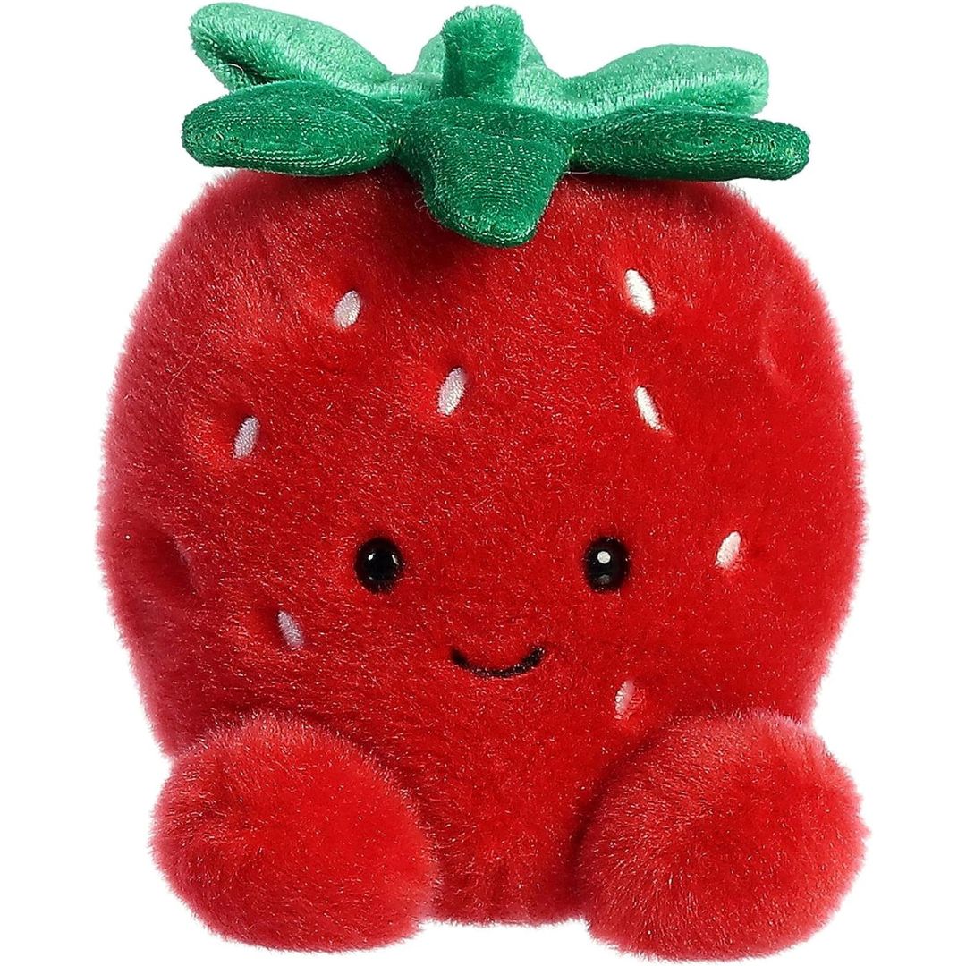 A stuffed animal toy shaped like a strawberry with a green leaf top, red body, and cute facial expression.