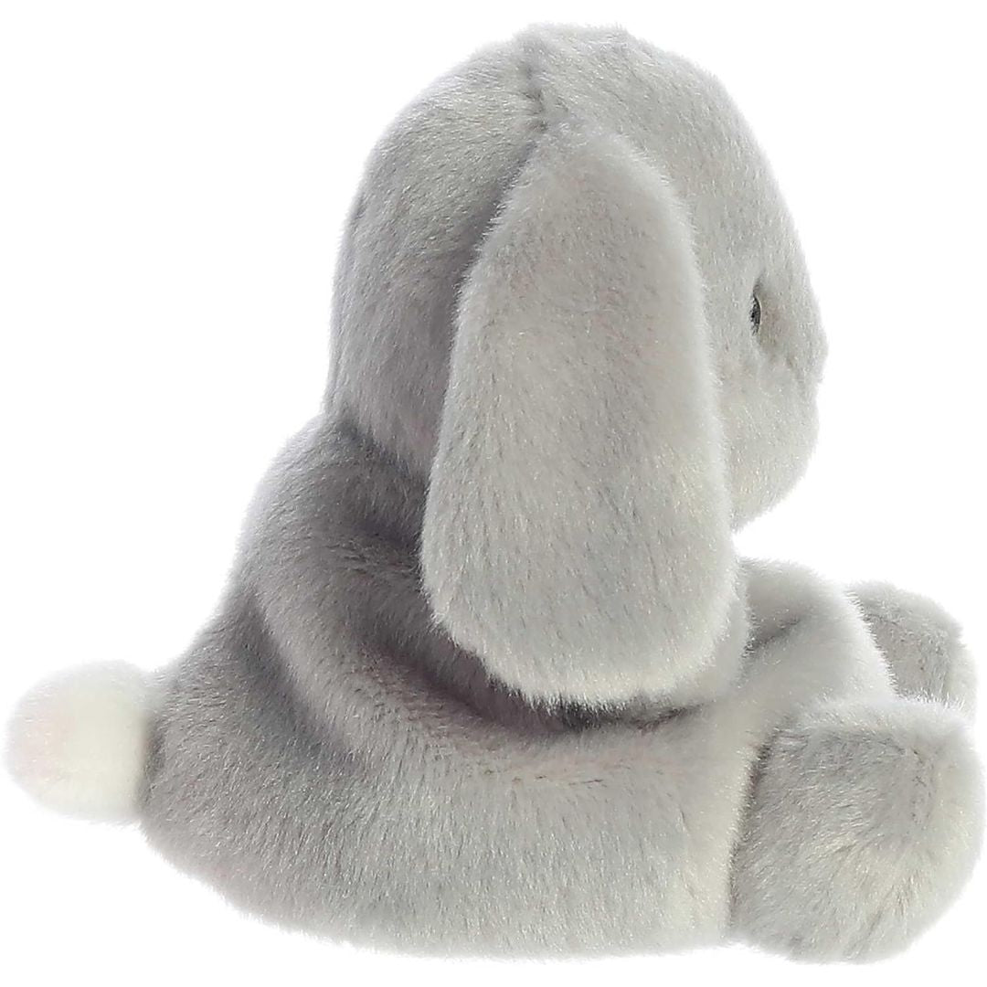 Side profile view of the Palm Pals grey bunny plush highlighting its round, perfectly squishy bean-weighted body and long floppy ear.