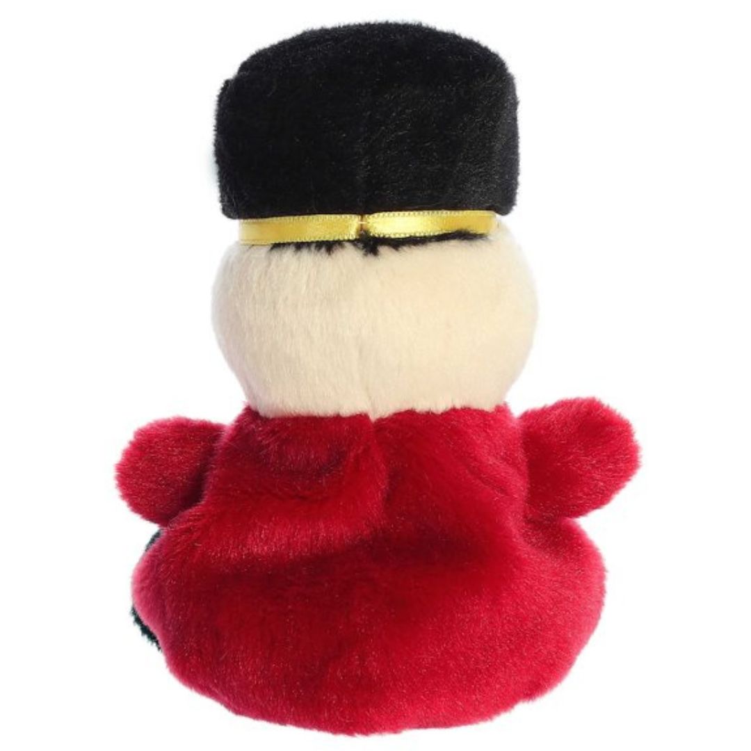 Rear view thumbnail of the Aurora holiday soldier stuffed toy displaying its smooth, solid red plush jacket and solid black hat from behind.